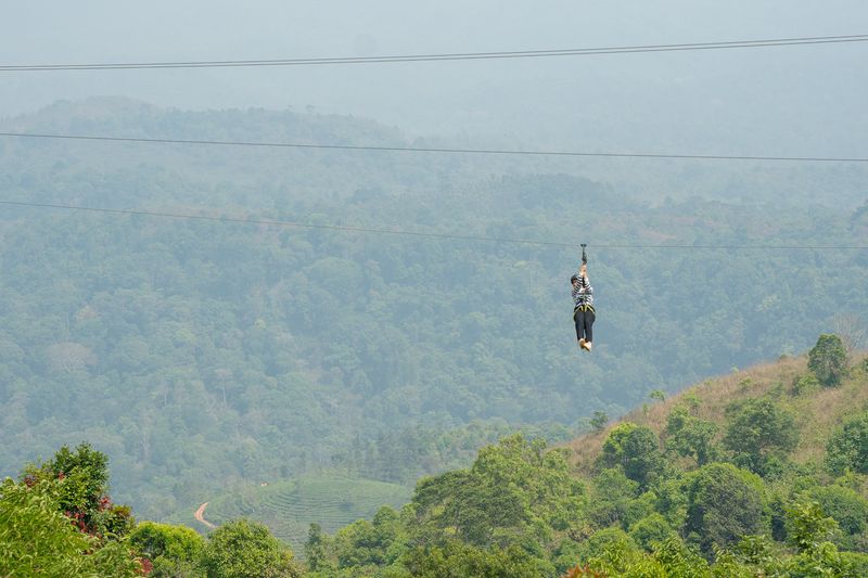 Guest ziplining high above the Western Ghats valley
