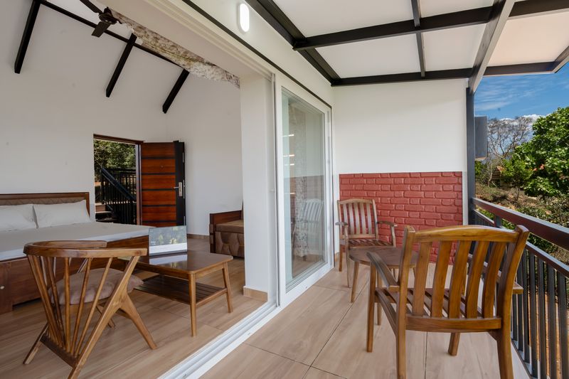 Room opening onto a balcony with exposed truss ceiling