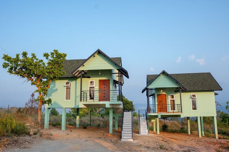 Twin cottages on stilts under a clear blue sky