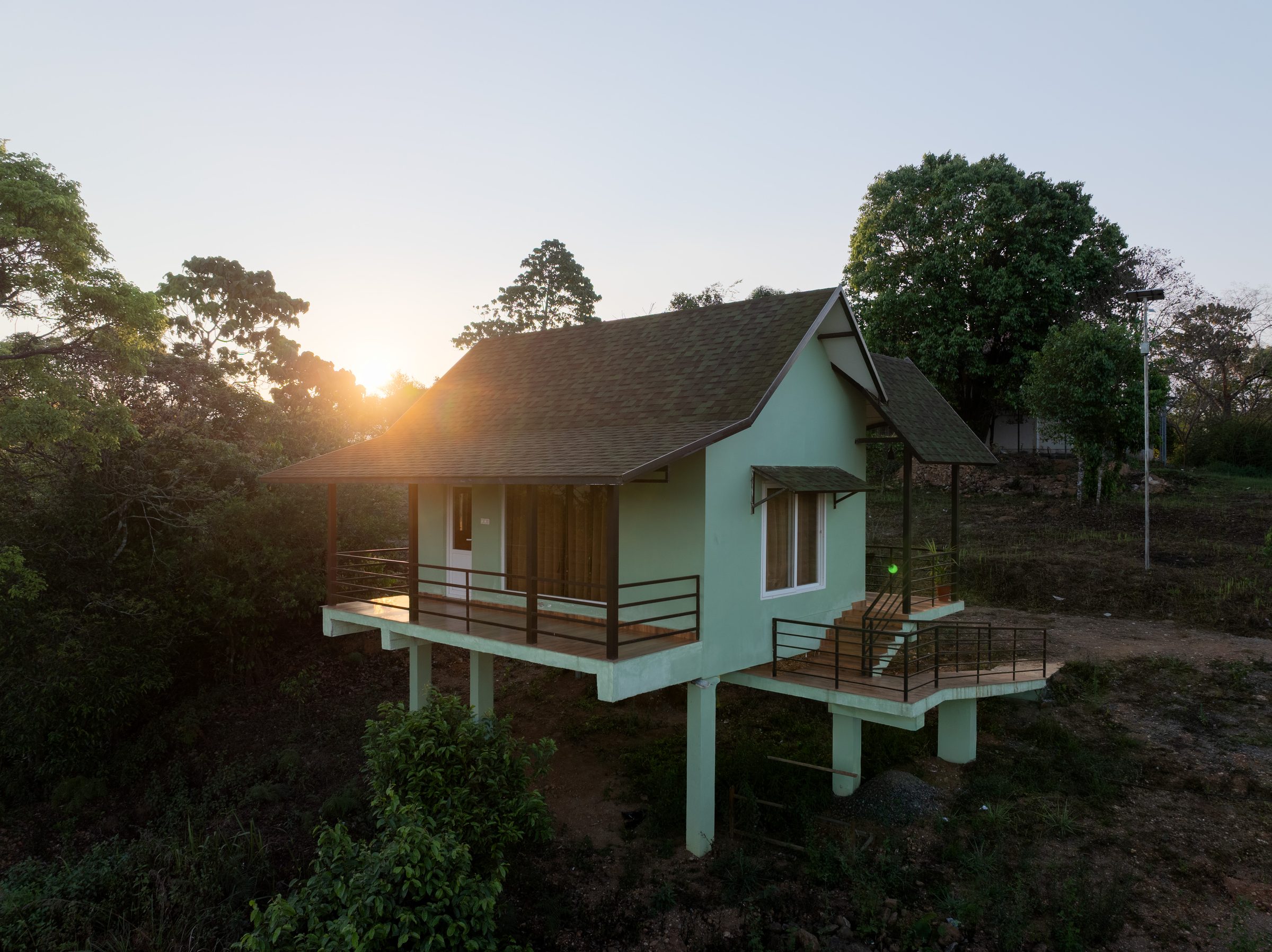 Cottage on stilts glowing at sunset over the Western Ghats